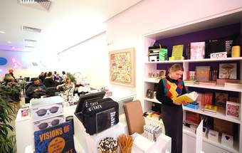 A visitor looking at a book in the Tate Liverpool + RIBA North shop