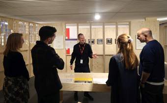 A photograph of a Visitor Engagement Assistant speaking to a small group of visitors