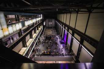 A view of a crowd seen from above in a large hall space