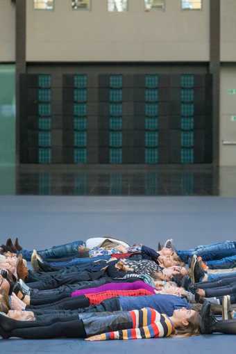 a group of people lying down on Turbine Hall's floor