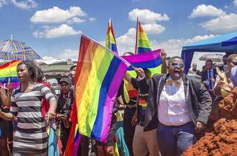 Colour photo of people waving rainbow flags