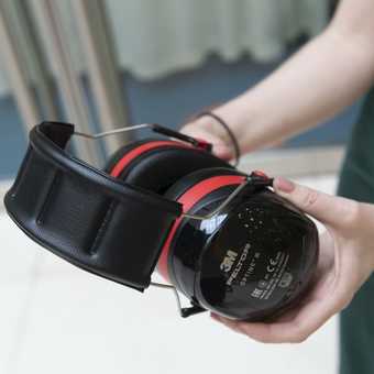 a person holds a set of ear defenders.