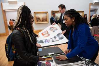 A student showing a teacher their sketchbook