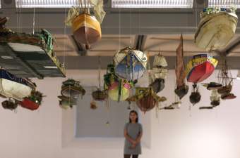 A visitor looking at a boat installation at Tate Liverpool