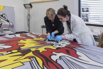 conservators treating a painting