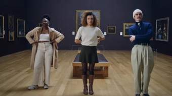 Three gallery visitors looking at an artwork in Tate Britain